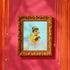 A chic rubber duck styled like Audrey Hepburn’s Holly Golightly, wearing a high bun, yellow bow, black gloves, and a sparkly choker. The duck floats in a pile of foam and is framed in white on a bubbly bathroom shelf with a red tile backdrop and soap dispenser.